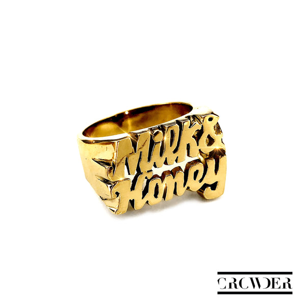 High definition photo of the Milk and Honey album art, displaying a gold ring with the text 'Milk & Honey' on top, and the artist's name 'CROWDER' at the bottom